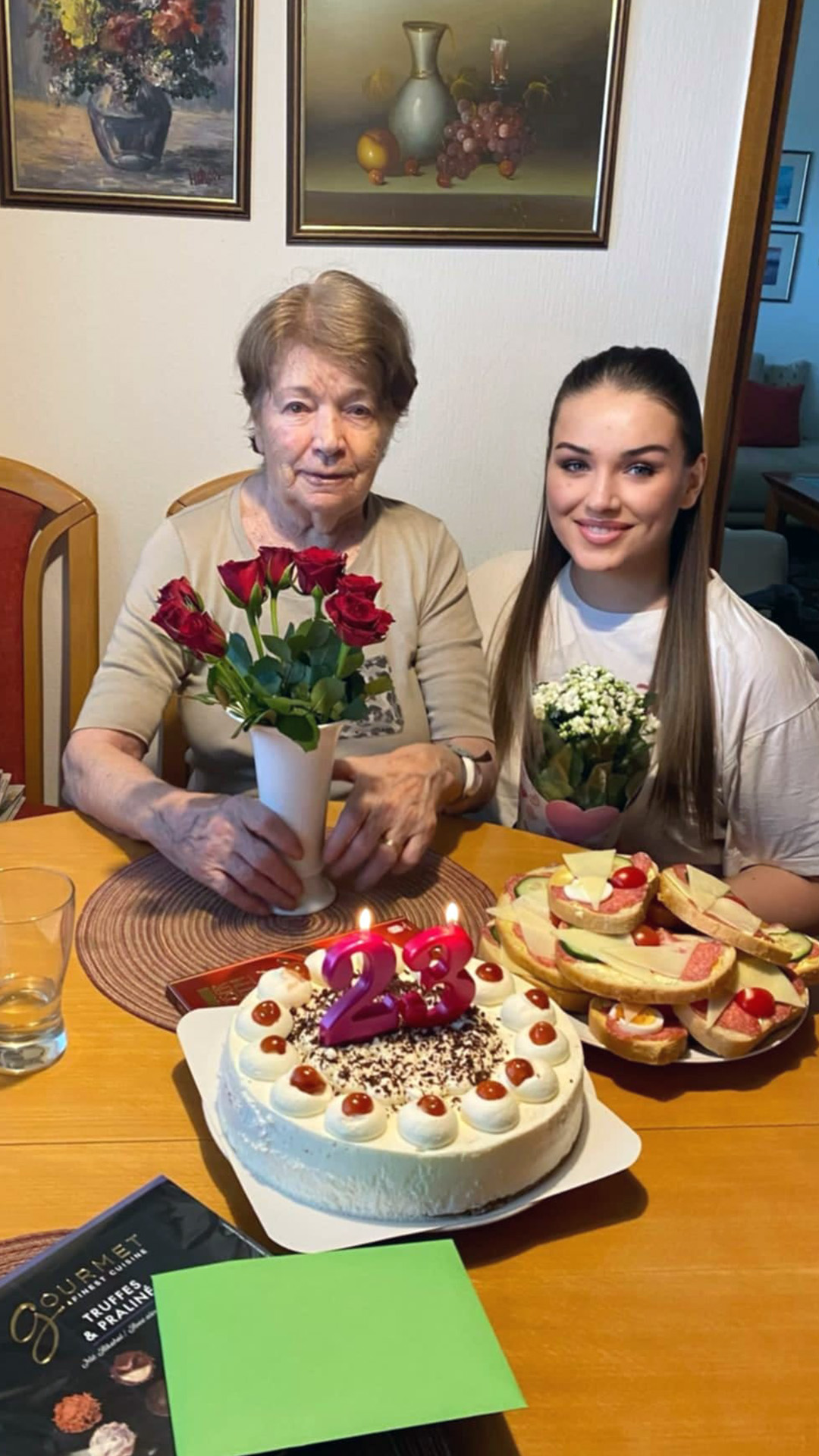 Über uns 14 Ältere Dame und Pflegerin von Lumen24Pflege sitzen im Esszimmer und feiern zusammen den Geburtstag der Pflegerin.