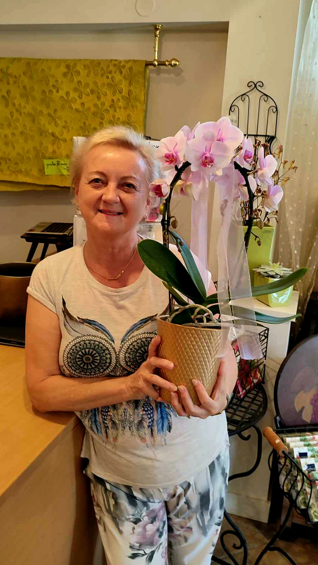 Über uns 10 Pflegerin hält einen Blumenstrauß in der Hand und lächelt dabei voller Freude.